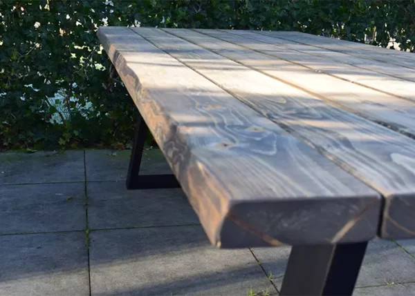 Sfeerbeeld van het tafelblad van de boomstamtafel buiten Quinn.