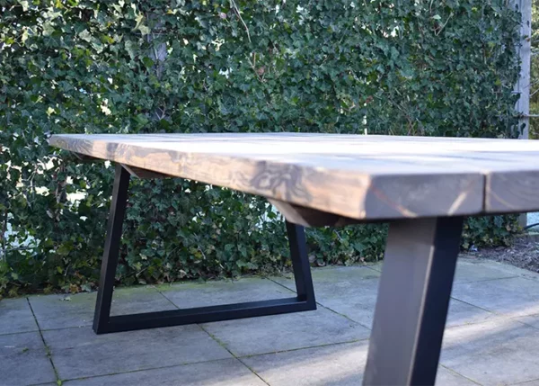 Sfeerbeeld van het tafelblad van de boomstamtafel buiten Quinn.